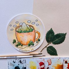 a watercolor painting of a cup of green tea with leaves on the table next to it