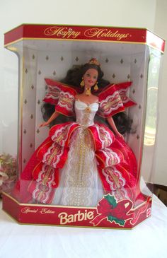 a barbie doll in a red and white dress with gold trimmings, wearing a tiara