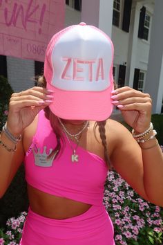 a woman wearing a pink tank top and hat with the word zeta on it