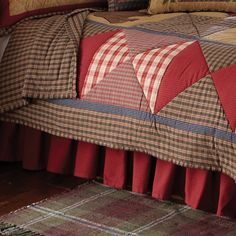 a bed with red and brown plaid bedspread on it's headboard