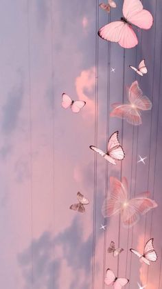 several pink butterflies flying in the sky with clouds and stars above them, all connected by strings