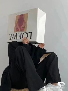 a man sitting on top of a chair holding a paper bag over his head with the word foeme written on it