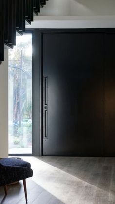 a modern entry way with black doors and stairs