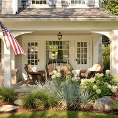 a patio with chairs and an umbrella in front of a house