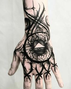 a person's hand with black ink on it and an abstract design in the middle