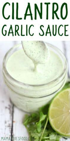 a small jar filled with cilantro and garnish sauce next to a lime slice