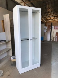 a tall white cabinet sitting inside of a warehouse