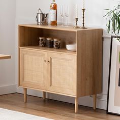 a wooden cabinet with glassware and bottles on it next to a white rug in a room