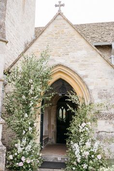 the entrance to an old church with flowers growing on it