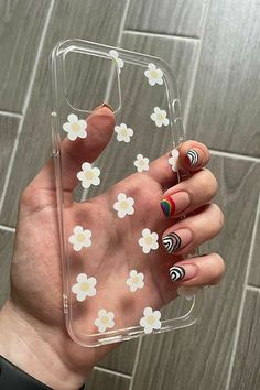 a woman's hand holding up a clear case with flowers on it