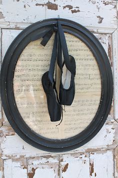 a pair of black shoes hanging from the side of a wall with an old book