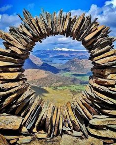 a stone arch with mountains in the background