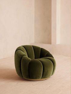 a green chair sitting on top of a hard wood floor next to a white wall