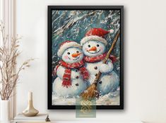 two snowmen are standing next to each other in front of a white wall with a black frame