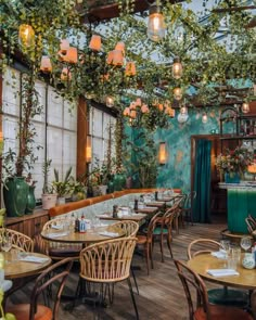 a restaurant with tables and chairs covered in plants