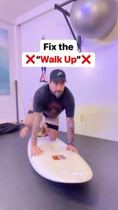 a man kneeling on top of a surfboard in front of a sign that says fix the walk up