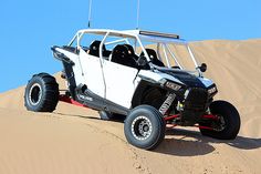 a white dune buggy driving through the desert