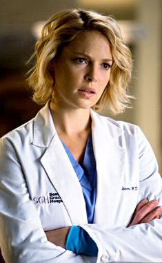 a woman in white lab coat standing with her arms crossed