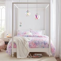 a white bed with pink and blue decorations on it