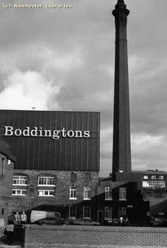 an old black and white photo of buildings with a sign that reads boddingtons