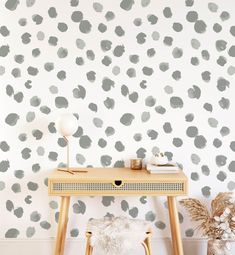 a desk with a chair and wallpaper in the background that has gray spots on it