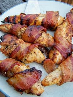 bacon wrapped chicken sitting on top of a white plate