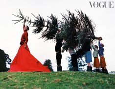 four people in long dresses are picking up trees