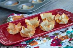 some kind of food that is on a red tray with muffin tins in the background