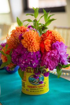 an arrangement of flowers in a bucket on a table