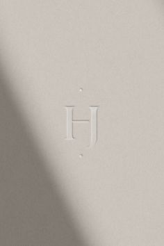 the letter h is placed on top of a white surface with a shadow from it