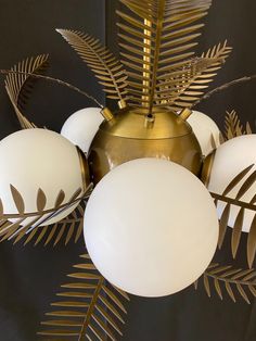 a golden chandelier with white balls and leaves