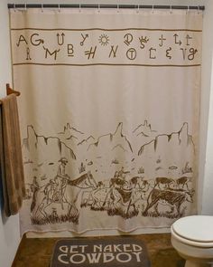 a bathroom with a shower curtain that has an image of cowboys on it