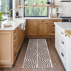 a kitchen with wooden cabinets and white counter tops, an area rug on the floor