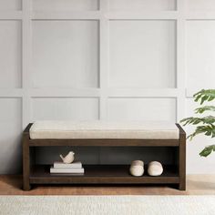 a wooden bench sitting next to a potted plant on top of a hard wood floor