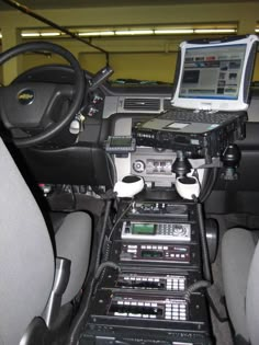 a laptop computer sitting on top of a dash board in a vehicle's dashboard