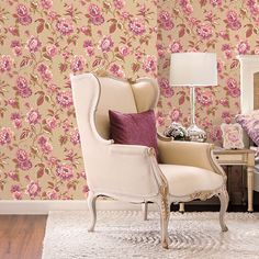 a chair and table in front of a wallpapered room with pink flowers on it