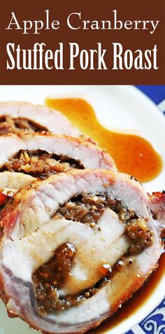 an apple cranberry stuffed pork roast on a blue and white plate with sauce