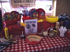 a table topped with lots of food and condiments next to a sign that says free hot dogs