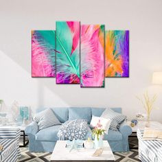 a living room filled with blue couches and colorful paintings on the wall above them