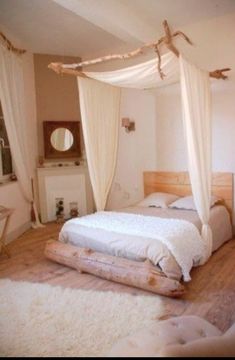 a white bed sitting inside of a bedroom on top of a hard wood floor