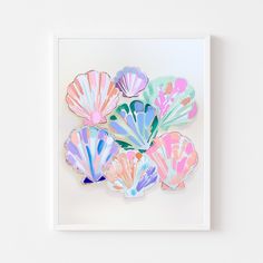 there are many colorful seashells on the white wall and one is pink, blue, green, yellow