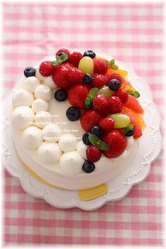 a cake decorated with fruit and marshmallows on a plate