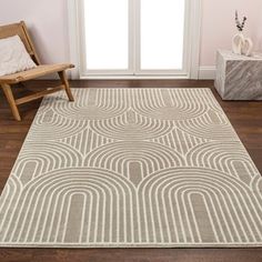 a white rug with an abstract design on it in a room next to a chair