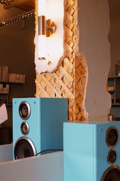 speakers are stacked on top of each other in front of a wall with peeling paint