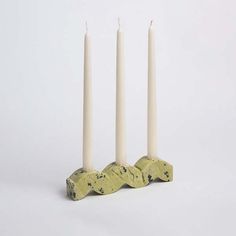 three white candles sitting next to each other