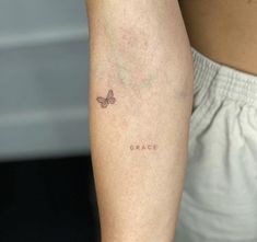 a close up of a person's arm with a small tattoo on it that says grace