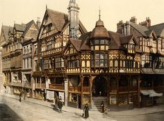 an old photo of people walking in front of buildings