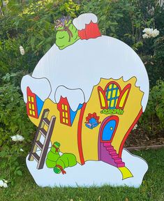 a large cardboard cutout of a house in the grass