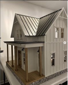 a model house is on display in a room with white walls and wood flooring