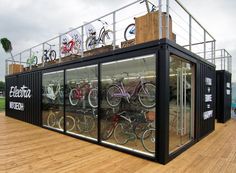 there are many bicycles in the display case on the wooden floored decking area